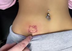 a hello kitty tattoo on the side of a woman's stomach is being shown