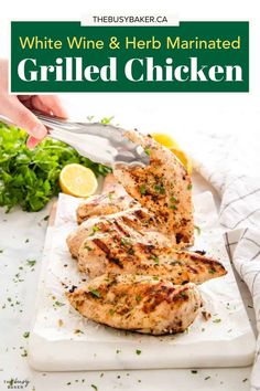 grilled chicken on a cutting board with lemon wedges and parsley