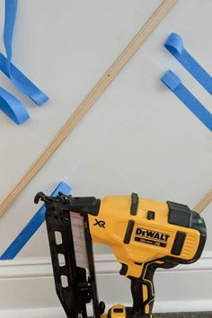 a cordless driller is on the ground next to some blue tape