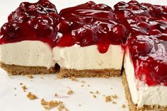 there is a cheesecake with red toppings on the top and one slice missing