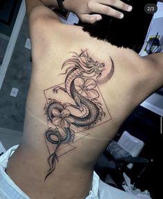 a woman's back with a tattoo on her stomach and a dragon in the middle