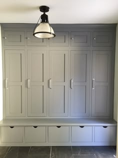 an empty room with white cabinets and drawers