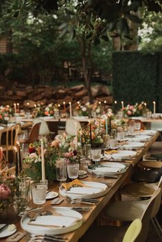 a long table with plates and candles on it