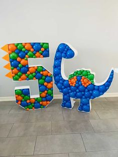 the number five is made out of balloons and has a dinosaur on it's back