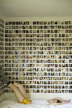 a woman standing in front of a wall covered with photos