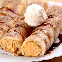 cinnamon roll with ice cream on top sitting on a white plate covered in syrup and powdered sugar