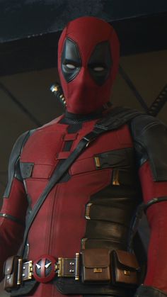 deadpool is standing with his hands in his pockets and looking at the camera while wearing a costume