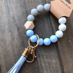 a blue beaded bracelet with a tassel and keychain hanging from it