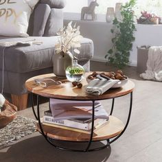 a living room filled with furniture and a coffee table on top of a wooden floor