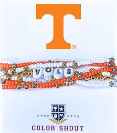 two orange and white beaded bracelets sitting on top of each other in front of the letter t