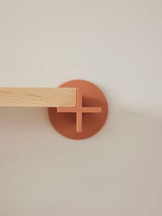 a wall mounted wooden object with a cross on it