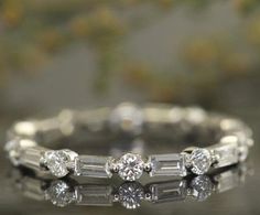 a close up view of a wedding ring with three stones on the side and one stone in the middle