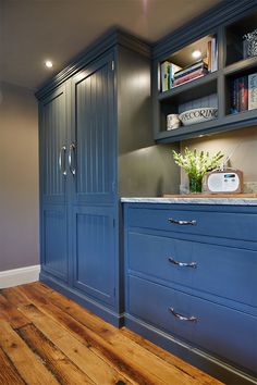 a kitchen with blue cabinets and wooden floors