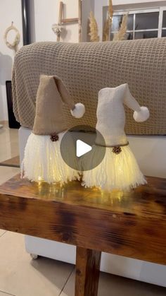 two little white pom poms sitting on top of a wooden table next to a couch