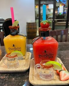 two drinks on trays with strawberries, lime and orange juice in the background