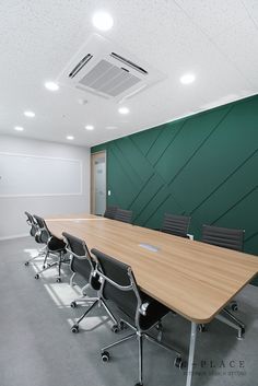 an empty conference room with green walls and black chairs