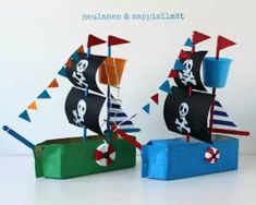 two paper boats with flags on them sitting next to each other