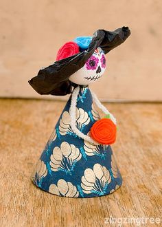 a small doll is wearing a blue and white dress with flowers on it's head