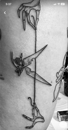 a woman's thigh with scissors and flowers on the side, as if it were cut in half