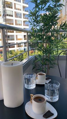 there is a cup of coffee on the table next to some cups and saucers