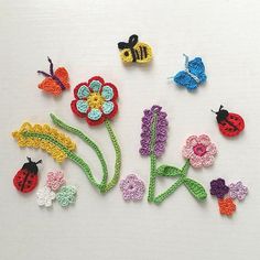 crocheted flowers and bugs on a white surface