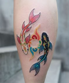 a woman's leg with two koi fish tattoos on it