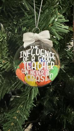 an ornament hanging from a christmas tree that says, in the presence of a good teacher