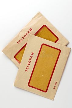 two brown envelopes with red lettering on them are sitting next to each other,