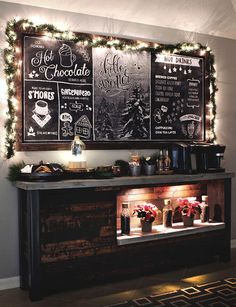 a bar with chalkboard menus on the wall and christmas lights hanging above it