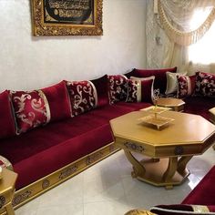 a living room filled with lots of red couches and pillows on top of each other