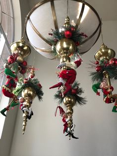 christmas decorations hanging from the ceiling in a room with a round light fixture above them