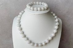 Natural white Burmese jadeite jade Bead size, approximately 10mm Handmade with love in Canada Necklace length 16.5" Button clasp High quality nylon cord Bracelet size, 14-20cm Durable elastic cord A set of a beautiful choker necklace and a stretch bracelet of 10mm natural white Burmese jadeite round beads. The necklace fits close and high at the neckline. Each jadeite bead is individually hand knotted on a high quality nylon cord and finished with a knotted button clasp. The bracelet is stretchy White Jade Beaded Jewelry, White Beaded Jade Jewelry, White Jade Jewelry With 8mm Beads, White Jade Jewelry With Gemstone Beads, White Single Strand Jade Jewelry, White Jade Round Beads Jewelry, White Adjustable Jade Necklace, Adjustable White Jade Necklace, Nylon Cord Bracelet