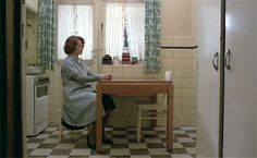 a woman sitting at a table in a kitchen