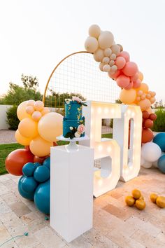 an arch made out of balloons with the number 50 on it and some other decorations