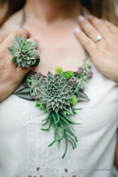 a woman wearing a necklace with succulents on it