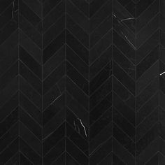 black marble chevroned tiles with white veining on the edges and bottom in diagonal pattern