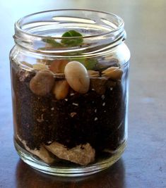 a glass jar filled with dirt and rocks