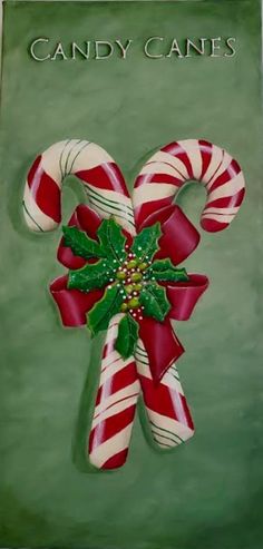 candy canes with holly on green background