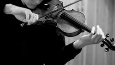 a woman playing the violin in black and white