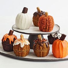 there are many small pumpkins on the cake plate