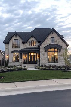 a large house with lots of windows on the front and side of it, surrounded by grass