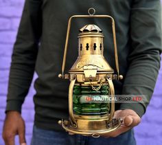 a man is holding an antique oil lamp in one hand and a green glass bottle in the other