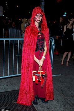 a woman dressed in red and wearing a cape