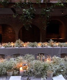 a long table is set with flowers and candles for an outdoor wedding reception at night