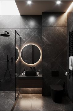 a modern bathroom with black marble walls and flooring, round mirrors on the wall