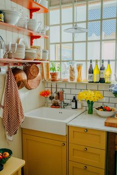 a kitchen filled with lots of clutter and dishes on top of a counter next to a window