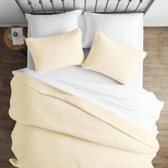 a bed with white sheets and pillows on top of it