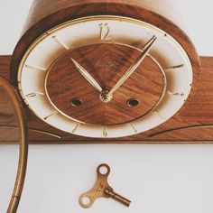 an old clock with a key attached to it