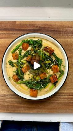 a bowl filled with soup on top of a wooden cutting board