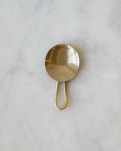 a gold spoon sitting on top of a white counter